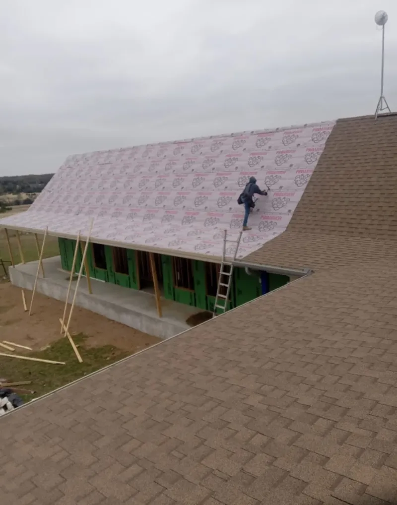 Worker preparing underlayment for a metal roof installation in Ponchatoula